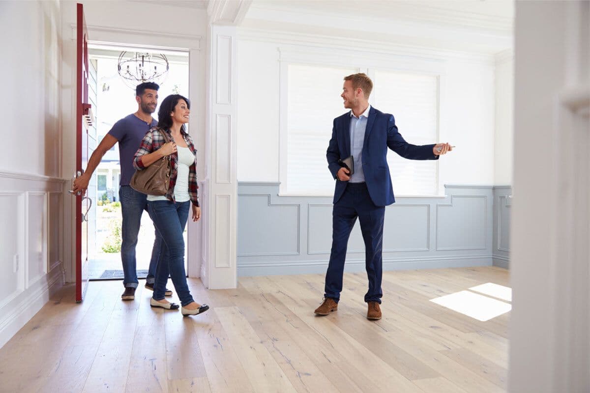 un agent immobilier qui fait visiter un appartement à un couple